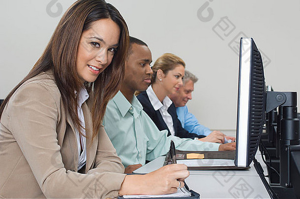 在教室中使用计算机的商务人员组，侧视图