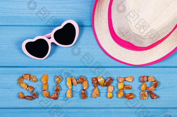 用琥珀石、草帽和太阳镜在蓝色木板上刻的铭文“夏天”，夏天和假期