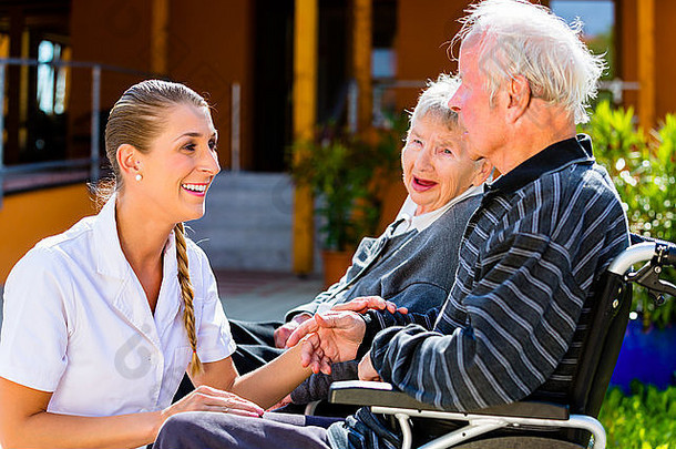 老人们，坐在轮椅上的一对男女，护士手牵着手