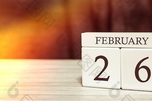 日历提醒事件概念。2月26日，阳光照射下，带数字和月份的木制立方体。