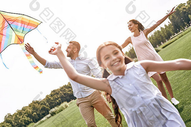 周末活动。一家人带着<strong>风筝</strong>走在大自然的田野上，微笑着，欢快地特写镜头