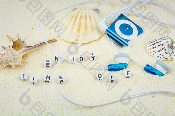 在沙滩上享受海贝壳和音频播放器之间的休息时间