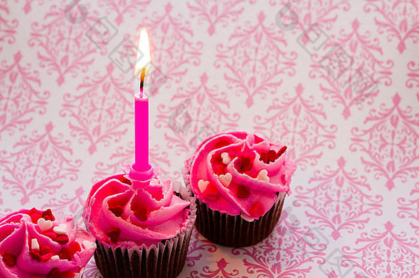 为情人节装饰的粉红色糖衣巧克力杯形蛋糕。