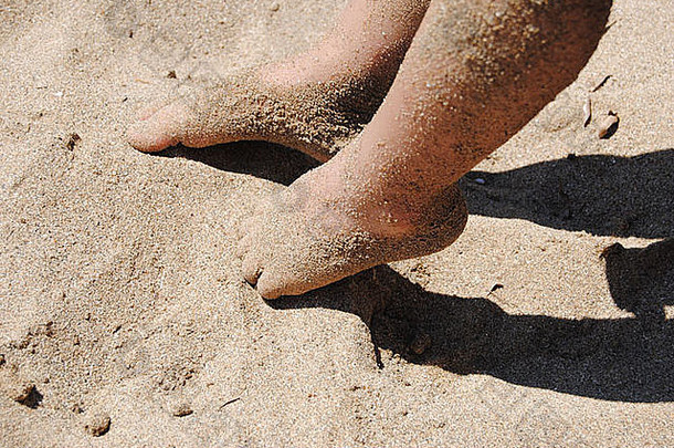 我儿子的脚在享受脚趾间温暖的<strong>沙粒</strong>。