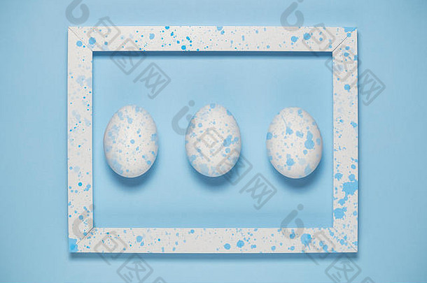在木制框架中平放白色鸡蛋，在蓝色背景上涂上蓝色油漆，这是一个最小的概念。