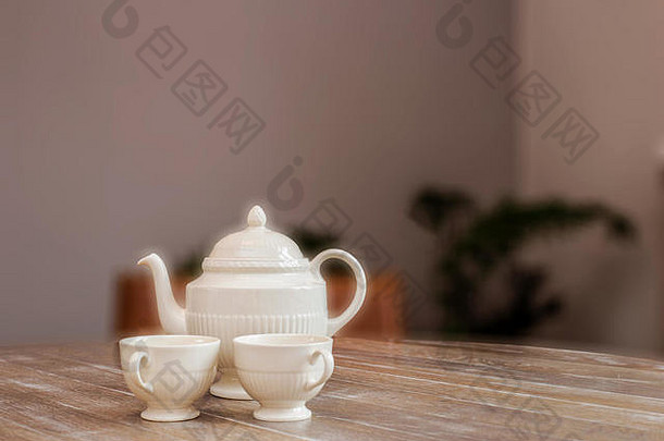 茶壶和茶杯放在木桌上，静物在家中复古设计可爱舒适，空间适合文字