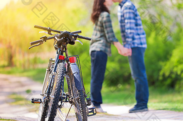 在博凯，两辆自行车在年轻的热吻情侣面前模糊地行驶