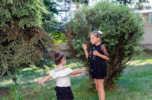 可爱的姐妹玩肥皂泡沫花园