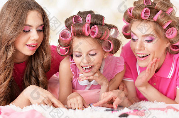 母亲和女儿们戴着卷发器