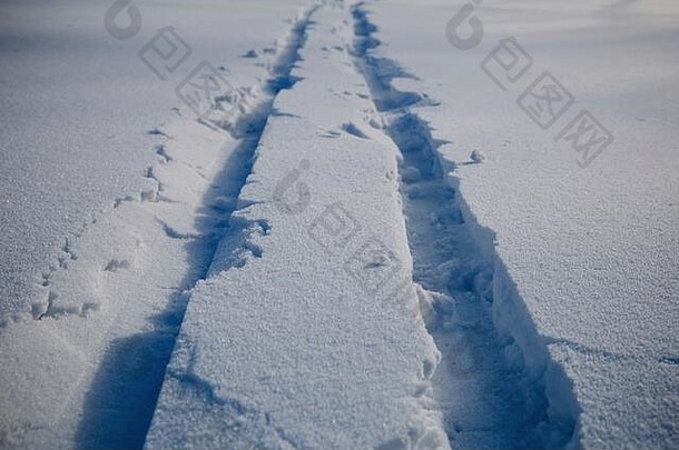 滑雪板<strong>上新</strong>鲜闪亮的雪中留下了深深的痕迹。雪倾泻在阳光下。<strong>冬季</strong>拍摄。