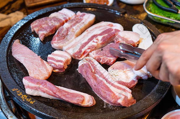 <strong>韩国</strong>餐厅的煎黑猪肉餐，新鲜美味的<strong>韩国</strong>美食，铁板上放着生菜，特写，空间，生活方式
