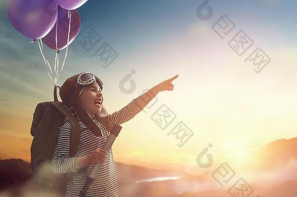 梦想旅行！在日落的背景下，一个坐着气球飞行的孩子。