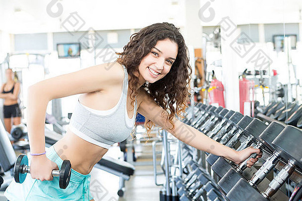 一个年轻漂亮的女人在健身房锻炼