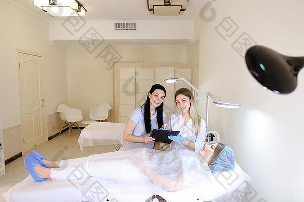 躺在医生和护士旁边的美容师柜旁的女孩。