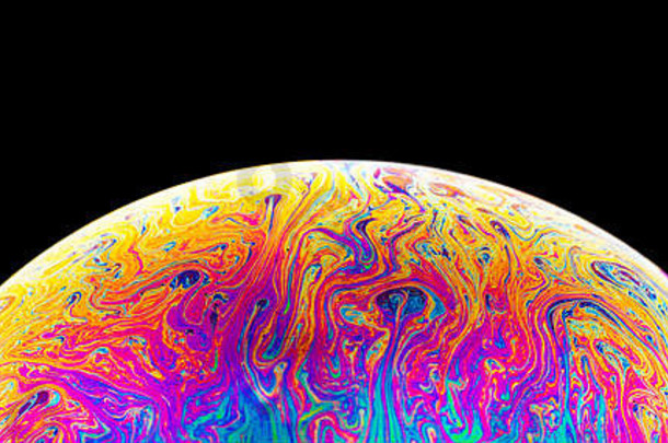 深色背景上的彩虹肥皂泡。彩色表面的特写。