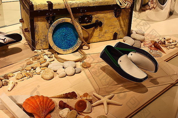 地板上随机摆放着海星、鹅卵石、贝壳、夏鞋、帽子