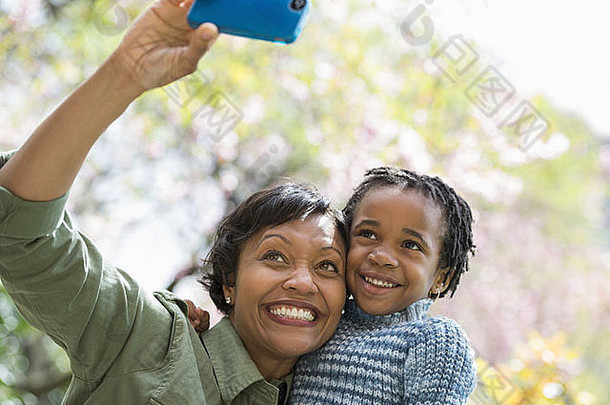 阳光与樱花一对母子用智能手机拍照