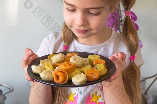 小女孩正在吃五颜六色的饺子。冠状病毒检疫概念。呆在家里。