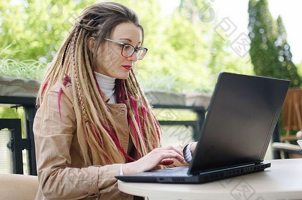戴着矫正视力<strong>眼镜</strong>、留着长发的女记者正在用笔记本电脑为下一次采访写问题