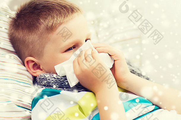 生病的男孩在家用纸巾擤鼻涕