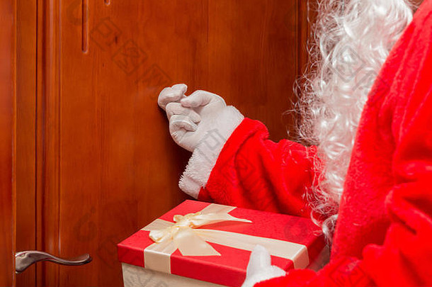 圣诞老人递着礼品盒敲门