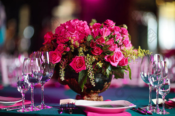 用粉红色玫瑰和绣球花在碗里插花。表格设置