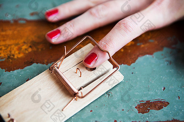 特写镜头女人的手指红色的nailpolish捕鼠器