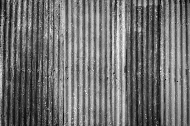 锈迹斑斑、波纹状的铁质金属建筑工地墙面纹理背景，带有黑白相间的渐晕图案。