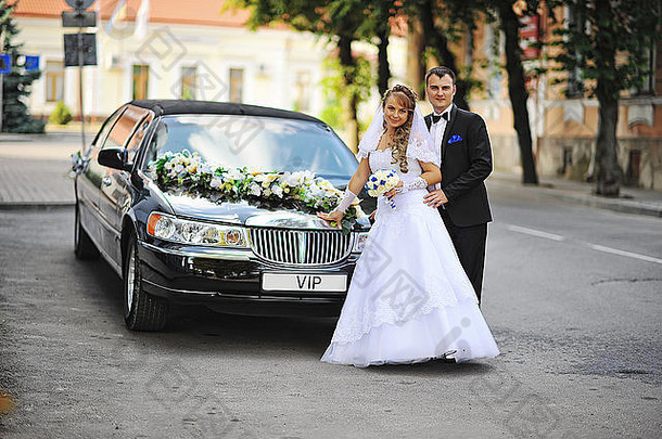 婚礼夫妇保持黑色的奢侈品豪华轿车