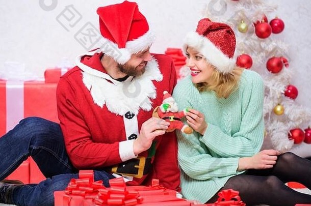 相爱的情侣用礼物欢度圣诞佳节。给爱人的礼物。家人准备了圣诞礼物。情侣们微笑着拥抱，打开圣诞树背景的礼物。