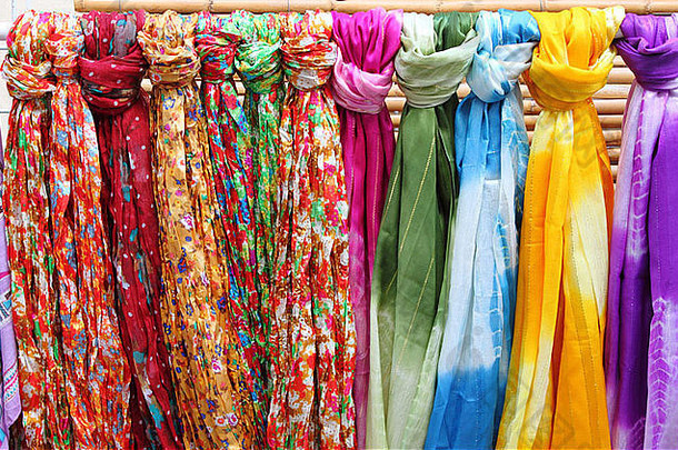 一家时装店的货架上挂着五颜六色的围巾