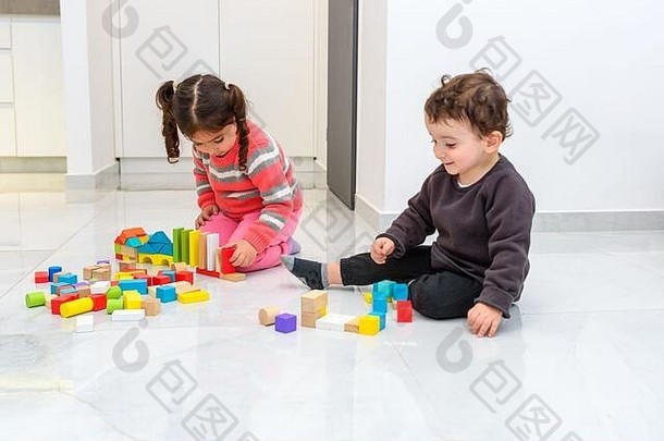 浪费年轻的孩子们玩塑料<strong>免费</strong>的木玩具建筑块孩子们挑选检查叠加块坐着地板上在室内首页幼儿园