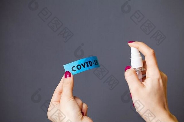 妇女在冠状病毒铭文上喷洒防腐剂的特写镜头