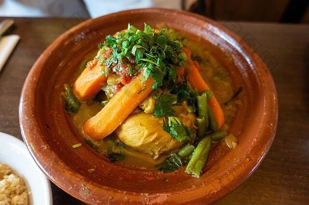 鸡肉塔吉恩，摩洛哥菜，配蔬菜，放在一个乡村陶器店。