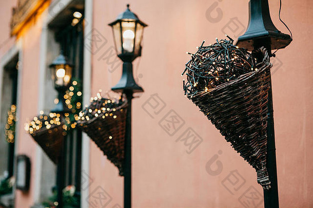 华沙街头的传统圣诞装饰品。用花环装饰的灯柱排在建筑物旁边。