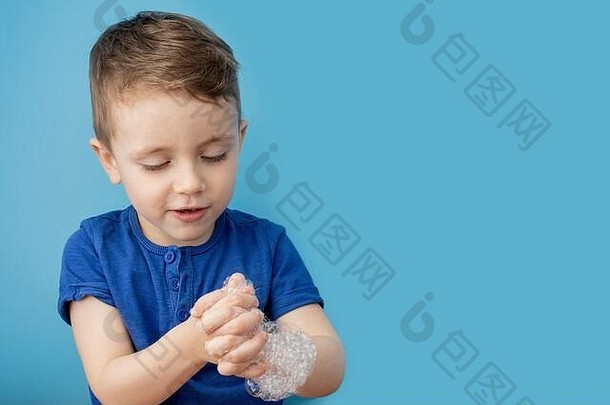 孩子用肥皂泡沫展示双手，清洁卫生理念。经常用水和肥皂洗手将有助于预防感冒