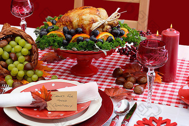 红色和白色主题感恩节餐桌，带有独立的位置设置、食物和聚宝盆。