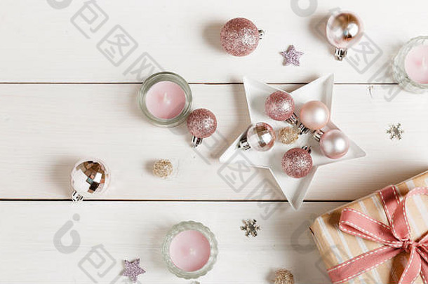 在白色木制桌子上准备圣诞礼物，桌上装饰有粉色装饰