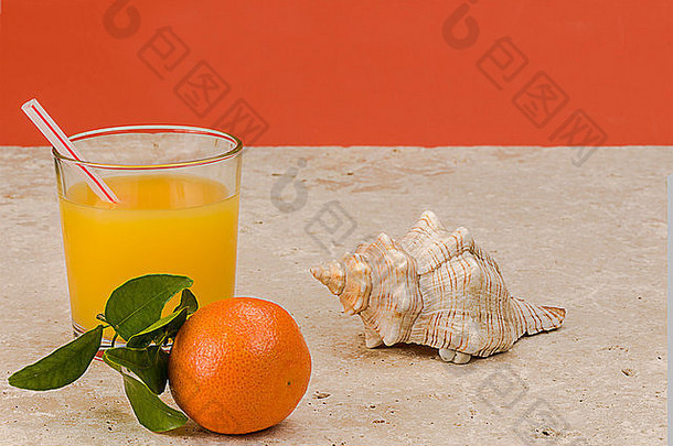 天然石头背景上的温州蜜柑，配一杯橙汁和贝壳