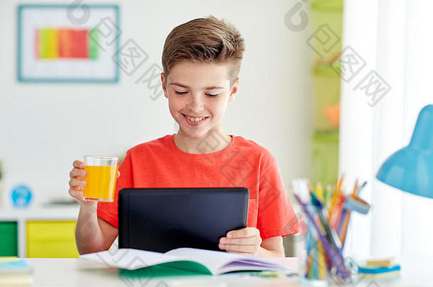 家里有平板电脑和果汁的学生男孩