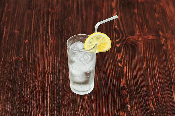 一杯加冰的新鲜柠檬水，木制背景的鸡尾酒