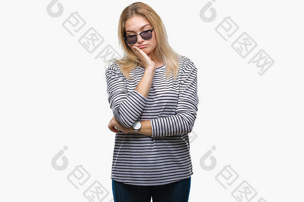 年轻的白人妇女戴着太阳镜，在孤立的背景下思考，双臂交叉，看起来很疲惫，对抑郁症感到厌烦。