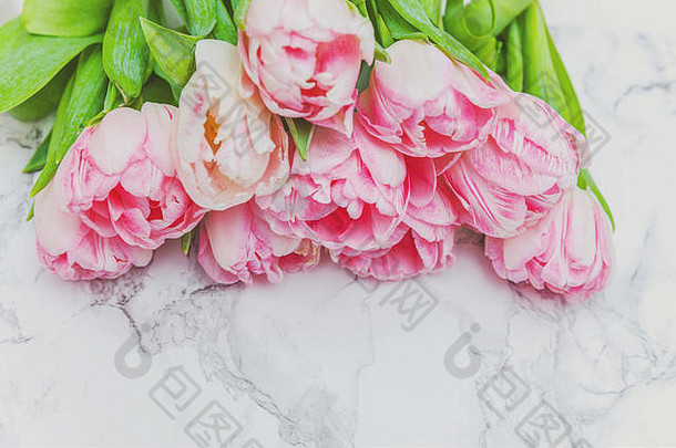 春天贺卡。大理石背景上的淡粉色郁金香鲜花。节日快乐复活节母亲节周年纪念情人节生日概念。平面俯视图空间