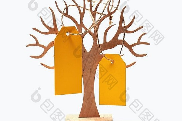 黄色空纸购物标签或用于价格、销售、销售或节日卡的空白纸板标签挂在木制装饰树上，隔离在白色背景上，空间