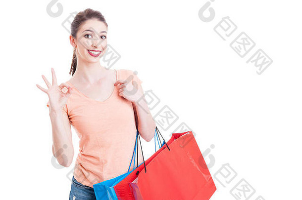 美丽的女士拿着购物袋，微笑着，在白色的广告区上显示出良好或完美的姿势