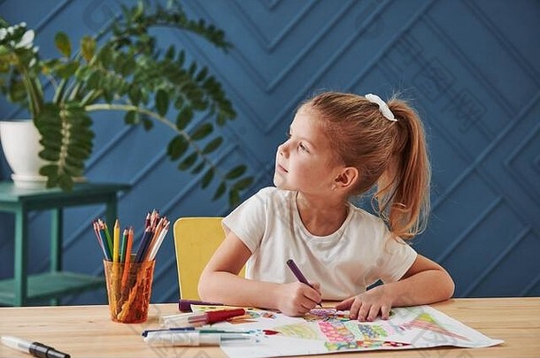 寻找想法。艺术学校里可爱的小女孩用铅笔和马克笔画出了她的第一幅画