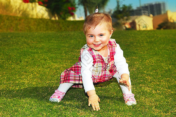 可爱的小女孩在户外绿草上玩耍