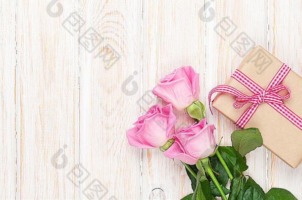 情人节一天背景粉红色的玫瑰木表格礼物盒子前视图复制空间