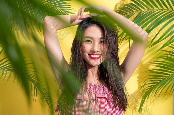 时尚美丽的亚洲女人在明亮的夏日背景下摆姿势微笑