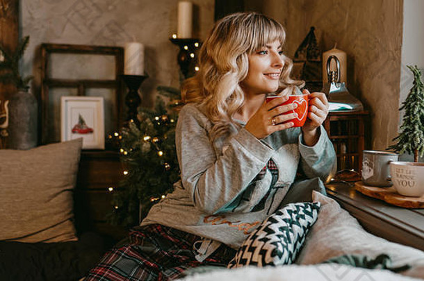 年轻的女人格子杯热茶圣诞节舒适的室内概念准备假期使梦想